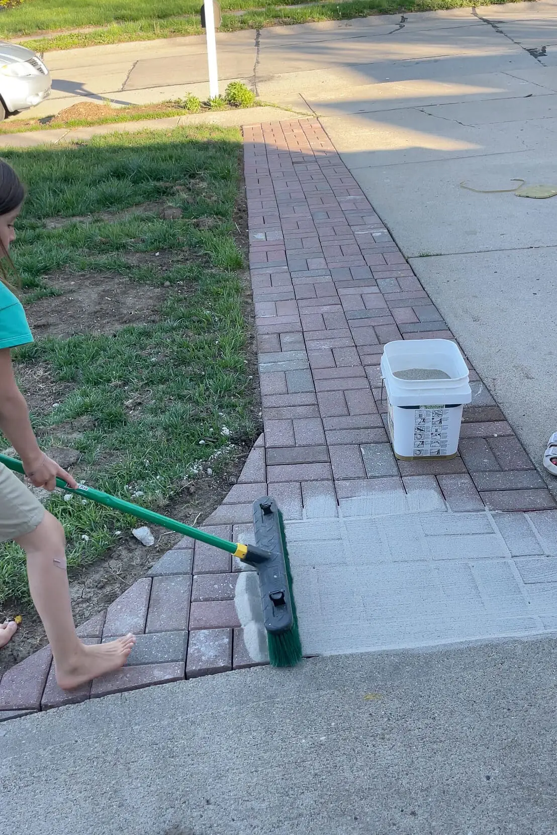Using polymer sand to finish a paver driveway extension.